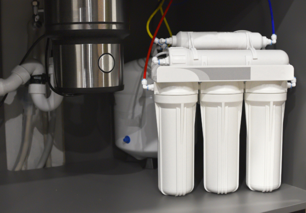 House water filtration system. Osmosis deionization system. Installation of water purification filters under kitchen sink in cupboard